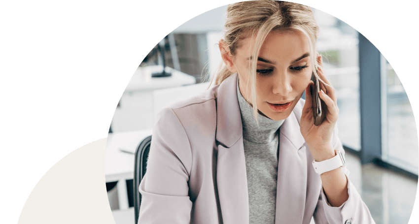 Femme d'affaire professionnelle parlant au téléphone en travaillant sur son ordinateur portable